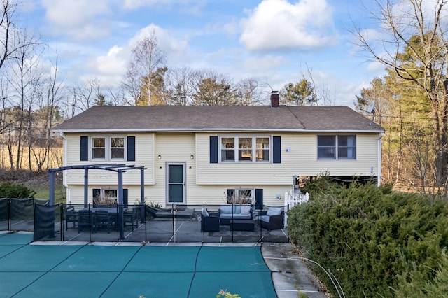 back of house with an outdoor living space, a patio, a covered pool, and a pergola