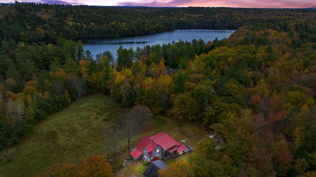 aerial view at dusk featuring a water view