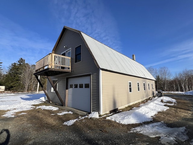 view of snow covered exterior with a garage and a balcony