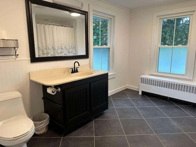 bathroom featuring tile patterned flooring, a healthy amount of sunlight, toilet, and radiator