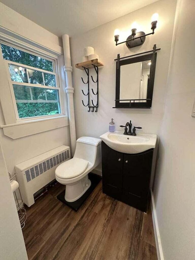 bathroom featuring radiator, vanity, wood-type flooring, and toilet