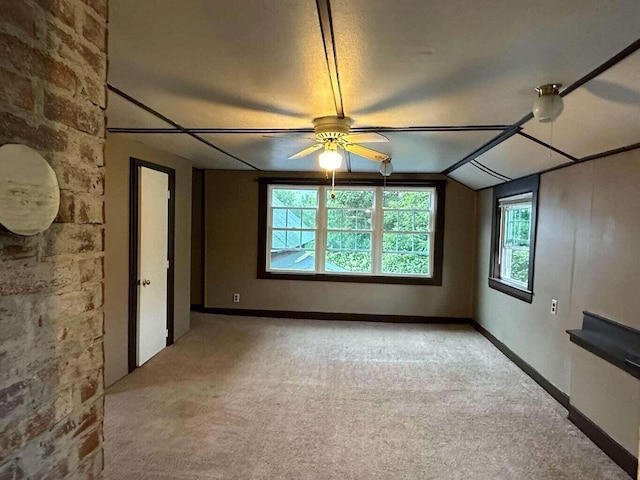 spare room featuring a textured ceiling, ceiling fan, light colored carpet, and lofted ceiling