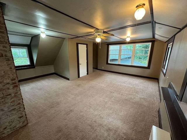 additional living space featuring a textured ceiling, ceiling fan, light colored carpet, and vaulted ceiling