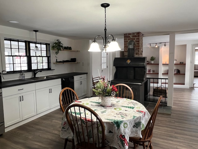 dining space with dark hardwood / wood-style floors, an inviting chandelier, and sink