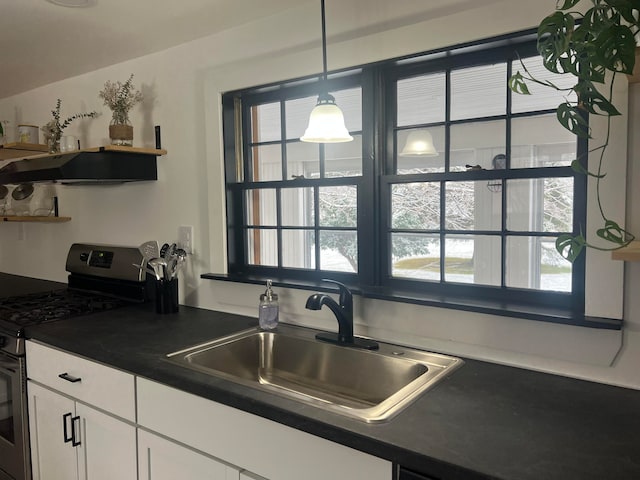 kitchen with gas range, plenty of natural light, white cabinets, and sink