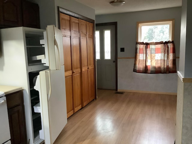 kitchen with white refrigerator and light hardwood / wood-style flooring