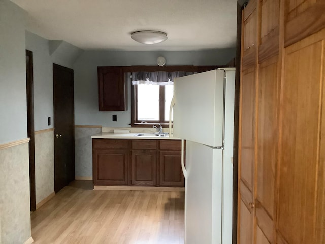 kitchen with sink, white fridge, and light wood-type flooring