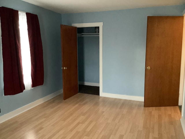 unfurnished bedroom featuring light wood-type flooring and a closet