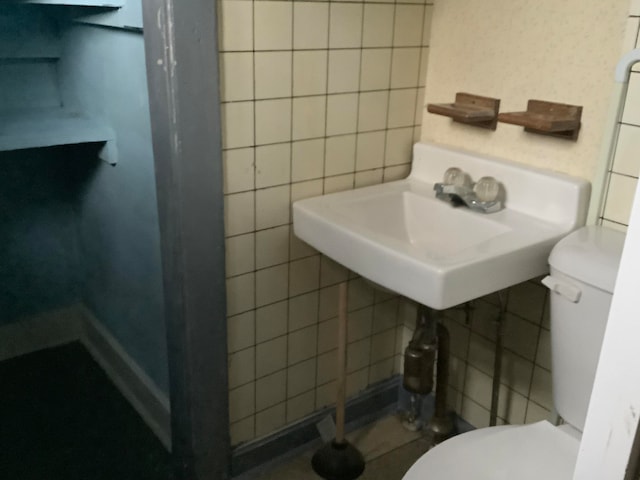 bathroom with tile walls and toilet