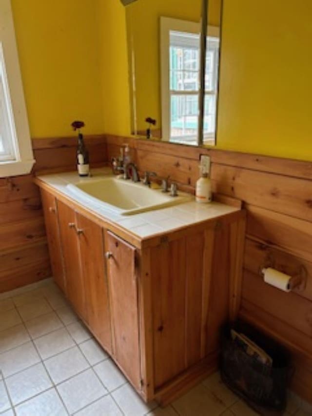 20 Monument Rd, Abbot, ME 04406 - bathroom featuring vanity, a wainscoted wall, wood walls, and tile patterned floors