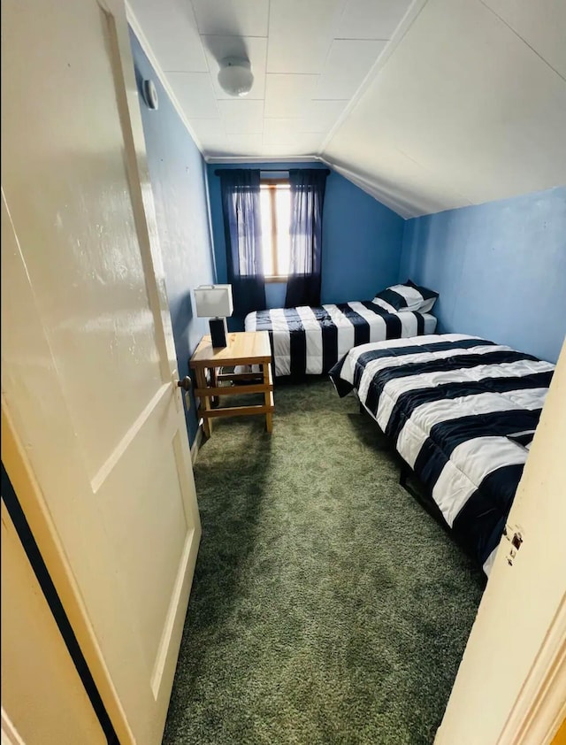 bedroom with dark colored carpet and vaulted ceiling