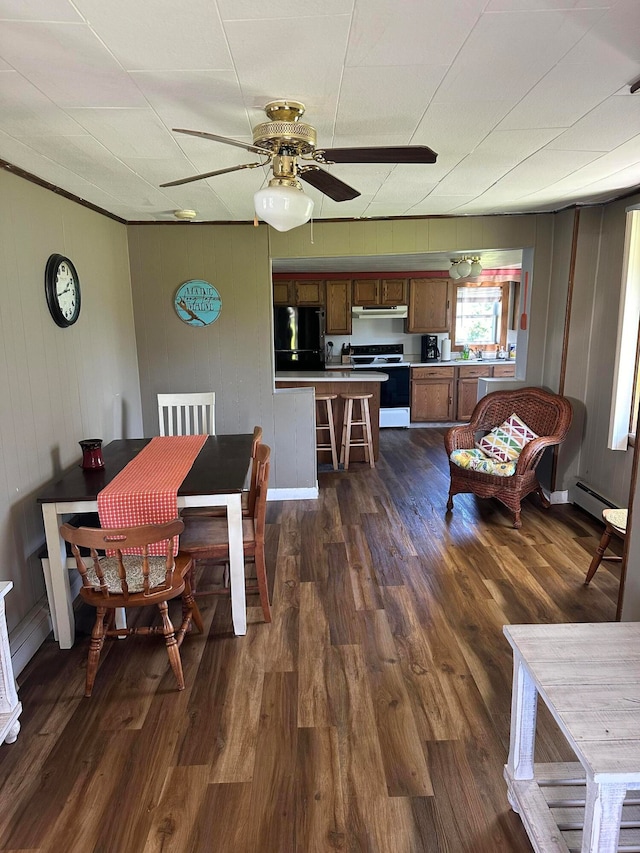 dining space with ceiling fan, dark hardwood / wood-style flooring, and baseboard heating