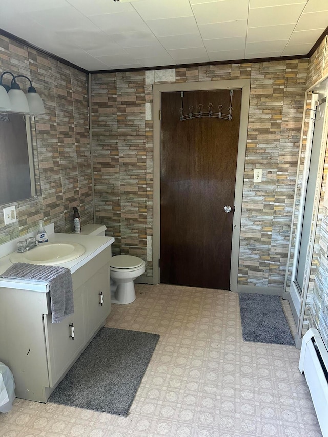 bathroom with vanity, a baseboard heating unit, tile walls, and toilet