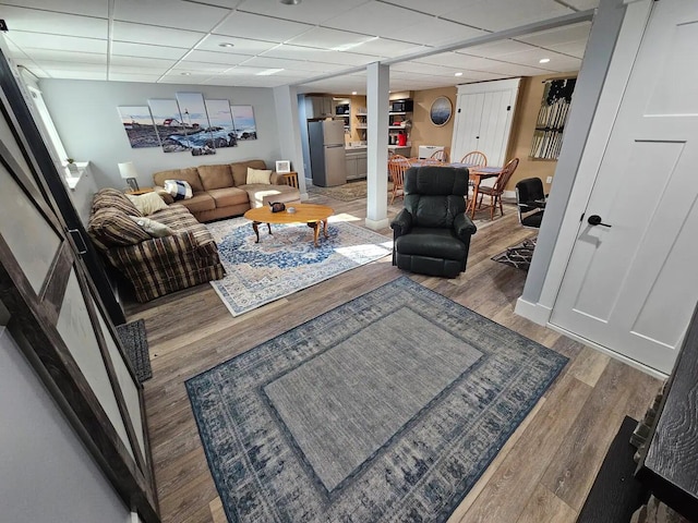 living room featuring a paneled ceiling and wood-type flooring