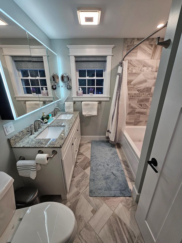 full bathroom featuring vanity, shower / tub combo, and toilet