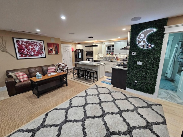 living room with light hardwood / wood-style flooring and sink