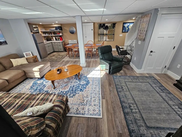 living room with hardwood / wood-style floors and a drop ceiling