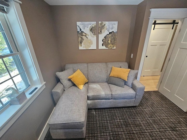 living room featuring a barn door and dark hardwood / wood-style flooring