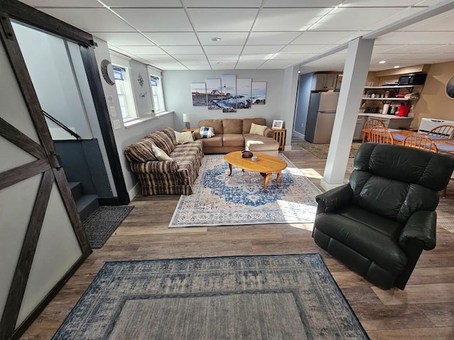 living room featuring a drop ceiling and hardwood / wood-style flooring