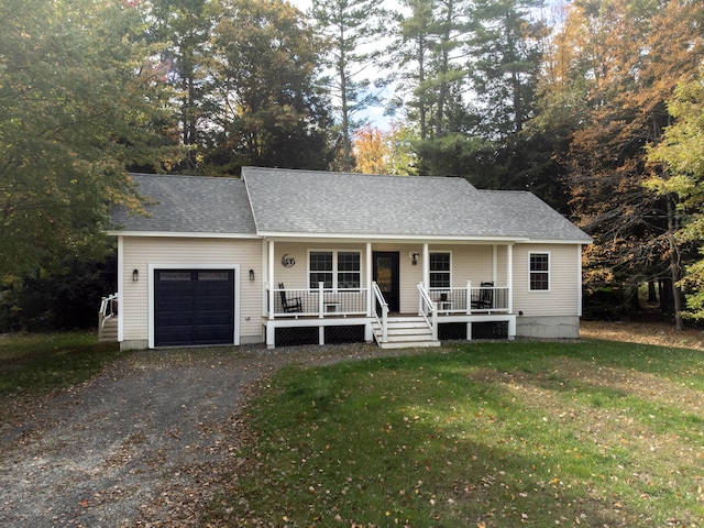 ranch-style home featuring covered porch, a garage, and a front yard