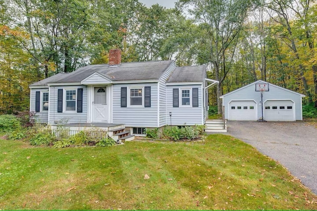 view of front of home featuring a garage, an outdoor structure, and a front lawn