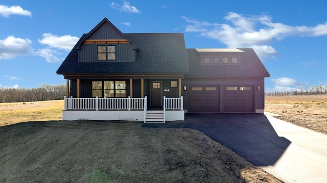 view of front facade with a front yard, a porch, and a garage