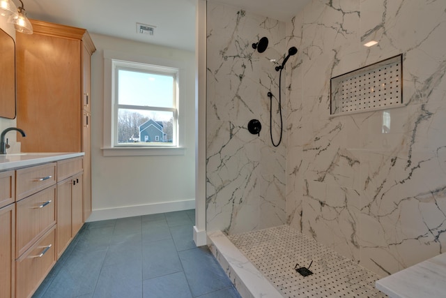 bathroom featuring tile patterned floors, vanity, and tiled shower