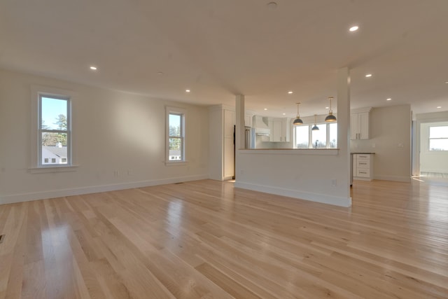 unfurnished living room featuring light hardwood / wood-style flooring and a wealth of natural light