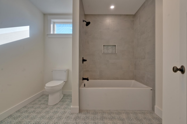 bathroom featuring toilet and tiled shower / bath