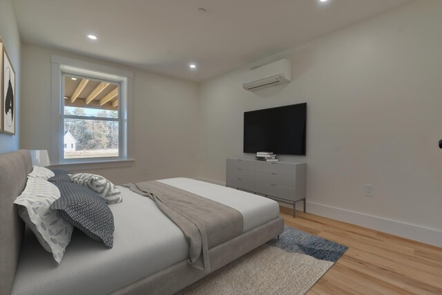 bedroom with light hardwood / wood-style flooring and a wall mounted AC