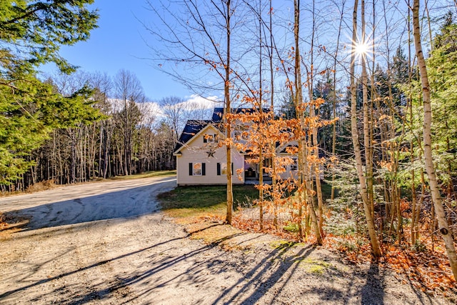 view of front of house featuring a forest view and driveway