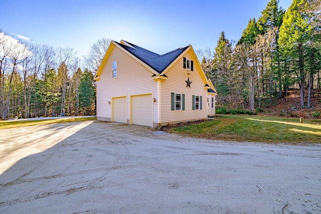 view of property exterior with a yard, driveway, and a garage