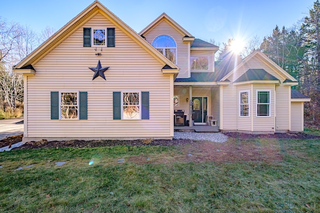 back of house with covered porch and a yard