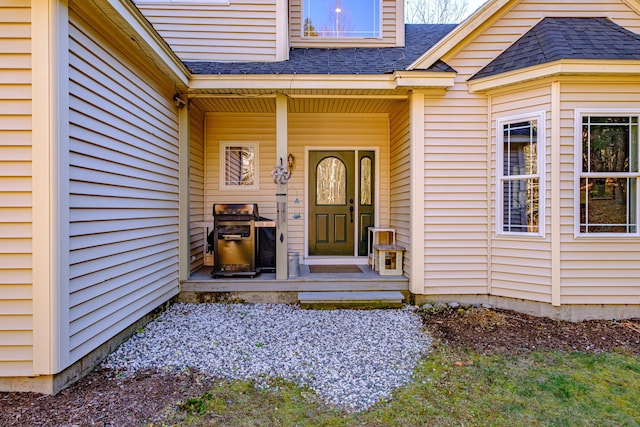 property entrance featuring a shingled roof