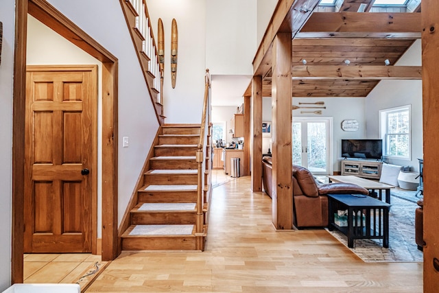 stairs with lofted ceiling with skylight and wood finished floors