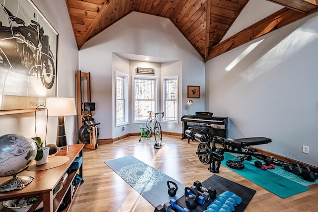 workout room featuring wooden ceiling, wood finished floors, baseboards, and high vaulted ceiling