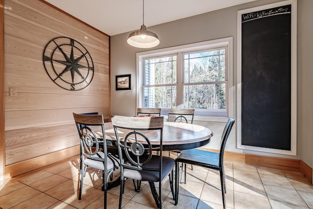 tiled dining area featuring wooden walls