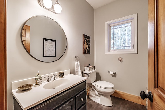 bathroom featuring vanity, toilet, and baseboards