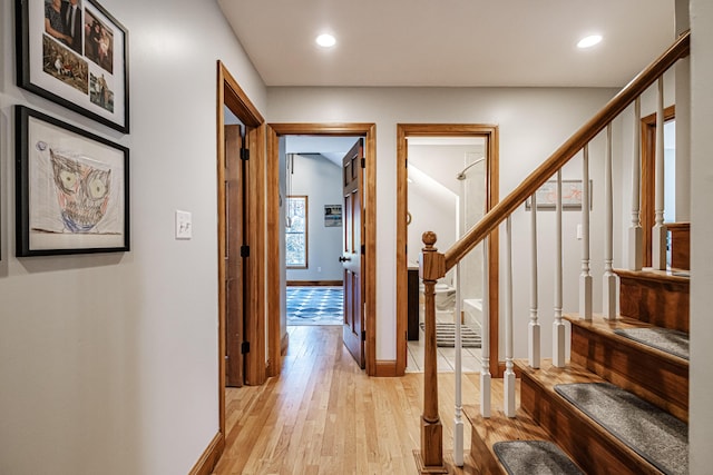 hall with stairway, recessed lighting, light wood-style floors, and baseboards