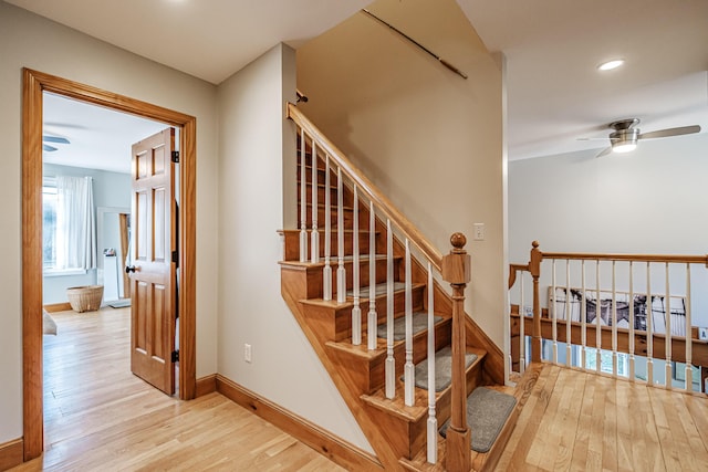 stairway featuring recessed lighting, a ceiling fan, baseboards, and wood finished floors