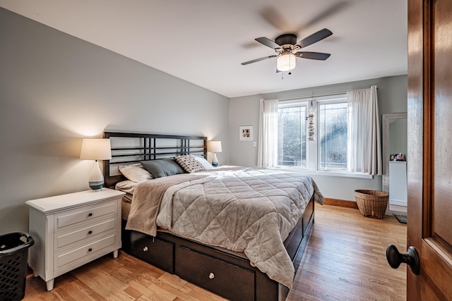 bedroom with light wood-style flooring, baseboards, and ceiling fan