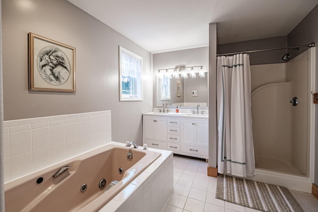 full bath featuring a sink, a tub with jets, double vanity, and tile patterned flooring