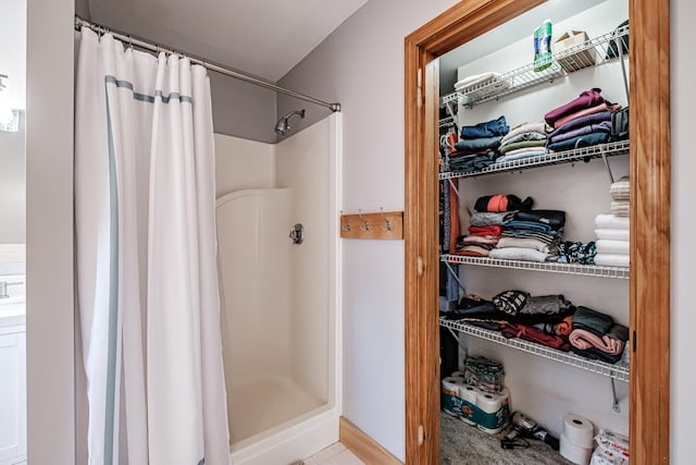 full bath featuring a spacious closet and a stall shower