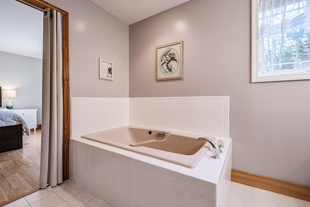 ensuite bathroom featuring tile patterned flooring, connected bathroom, and a bath