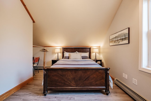 bedroom featuring baseboards, lofted ceiling, baseboard heating, and wood finished floors