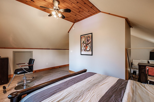 bedroom featuring wood finished floors, baseboards, and vaulted ceiling