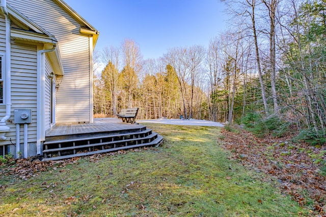 view of yard featuring a wooded view and a wooden deck