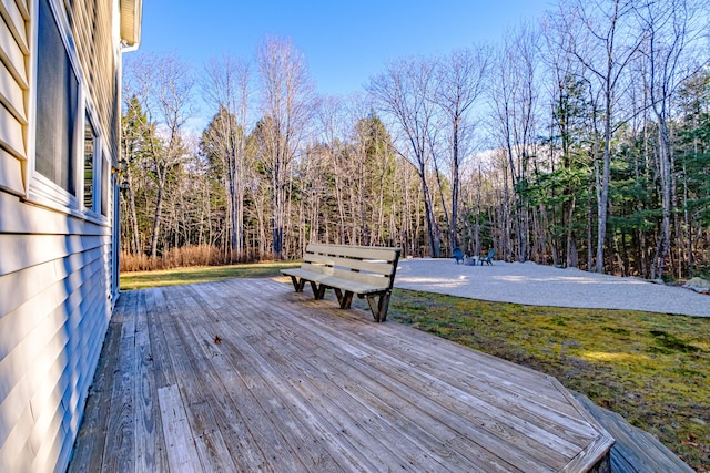 deck featuring a view of trees and a lawn