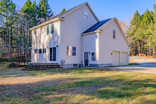 exterior space featuring a lawn, an attached garage, and driveway