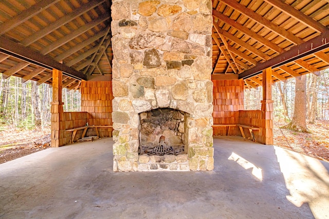 unfurnished living room featuring vaulted ceiling with beams and concrete floors